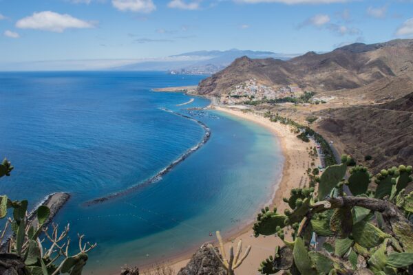 Panoramski pogled na obzorje Santa Cruz de Tenerife s sodobno arhitekturo in gorami v ozadju.