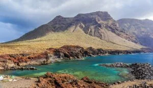 A scenic view of Punta de Teno in Teno Rural Park, with rugged cliffs meeting the sea under a clear blue sky.